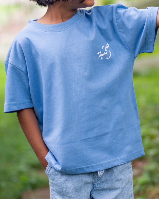 Child wearing a blue t-shirt with a logo outdoors